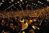 The crowd listens intently and gives generously during the offering